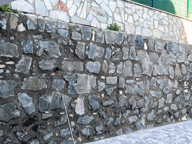 Bahçedeki taş duvarın bağlantıları ve derzlerinin onarım hazırlığı