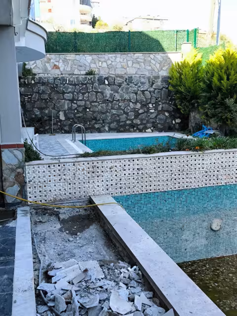 Boşaltılmış villa havuzu ve yenileme öncesindeki havuz çevresi