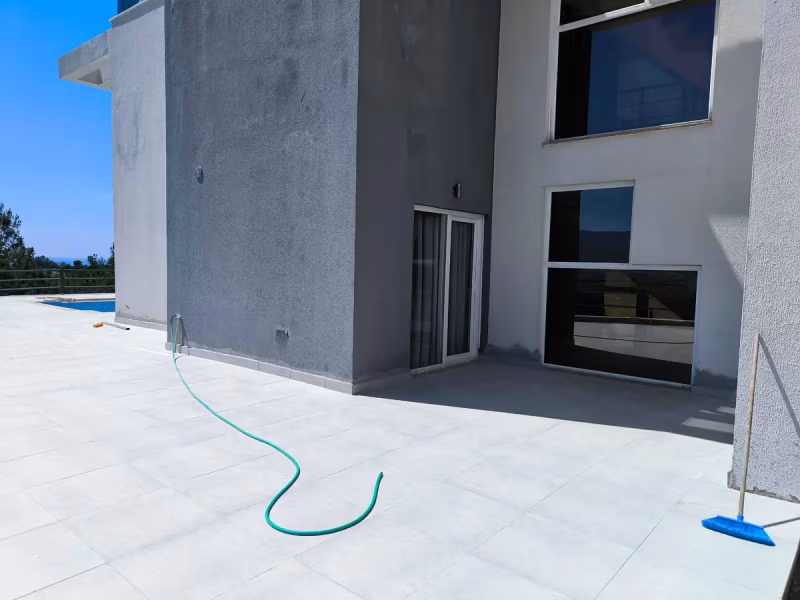 Soğucak’ta özel havuzlu villada doğru eğimle yenilenen geniş teras ve yapı cephesi