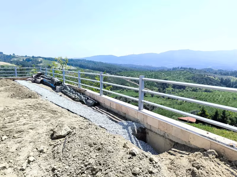 Bahçe kenarında geotekstil ve mıcırla hazırlanan drenaj yatağı